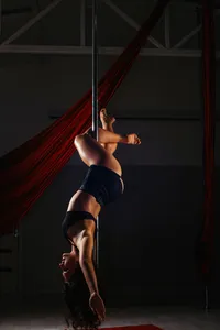 An artistic shot of a woman in a graceful upside-down pose on a pole, highlighting the creative potential of AI companions.
