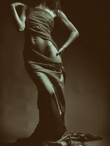 A stylised monochrome photo of a woman mid-movement in draped fabric, illustrating dance and movement AI girlfriend video ideas.