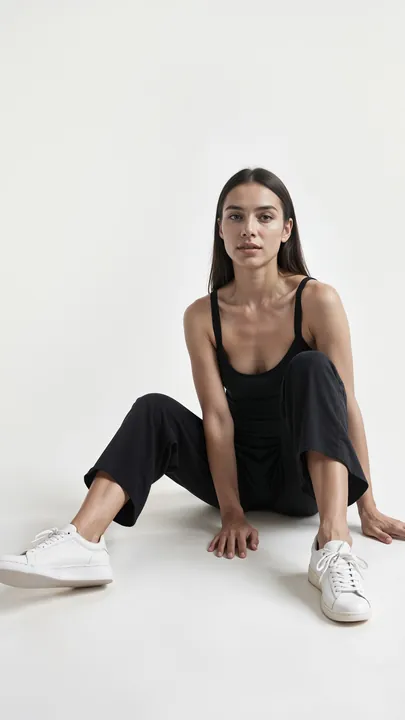 Reference woman-black-outfit-sitting-white-background.webp